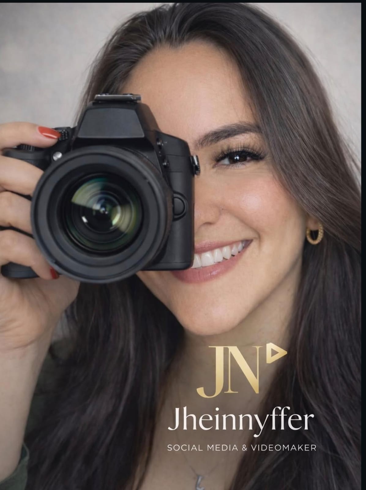 Jhennyfer Nascimento segurando uma câmera fotográfica